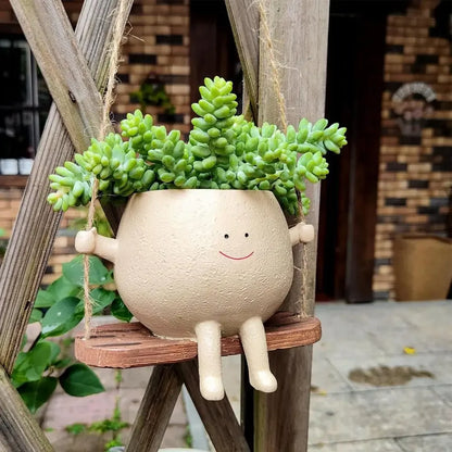 jardiniere exterieure sur balancoire dans la cour bonhomme sourire